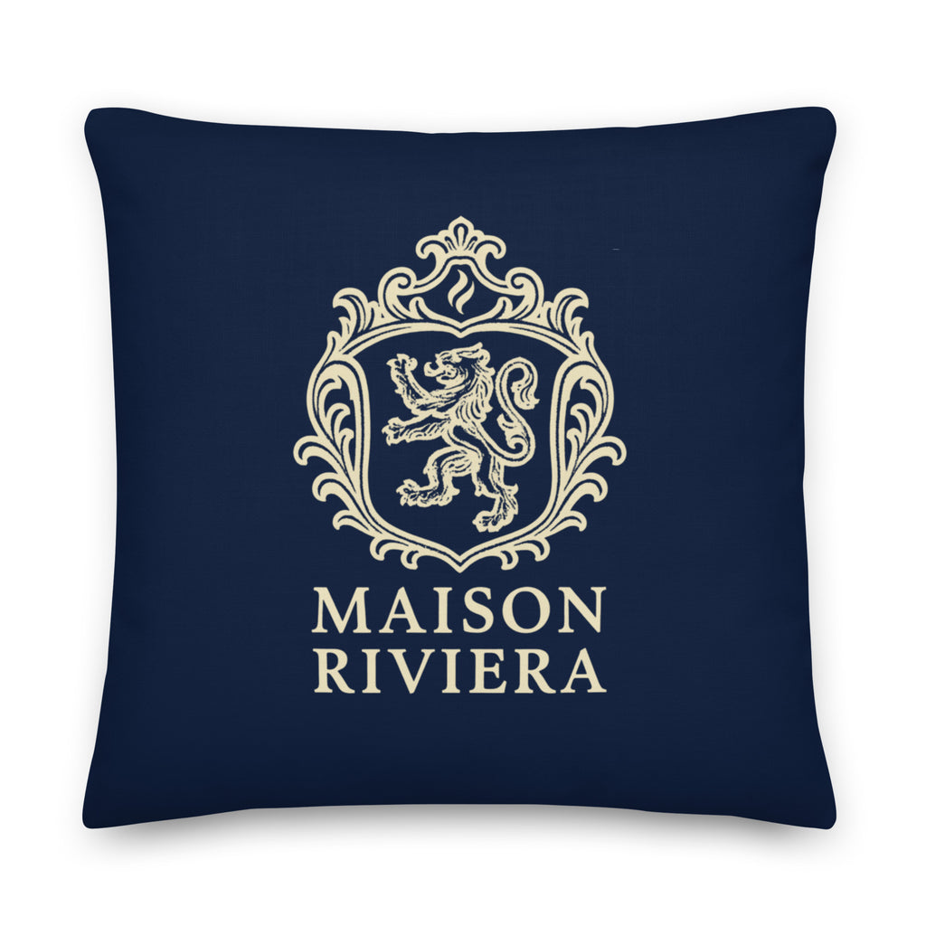 Navy blue pillow with gold crest and 'Maison Riviera' text on a white background